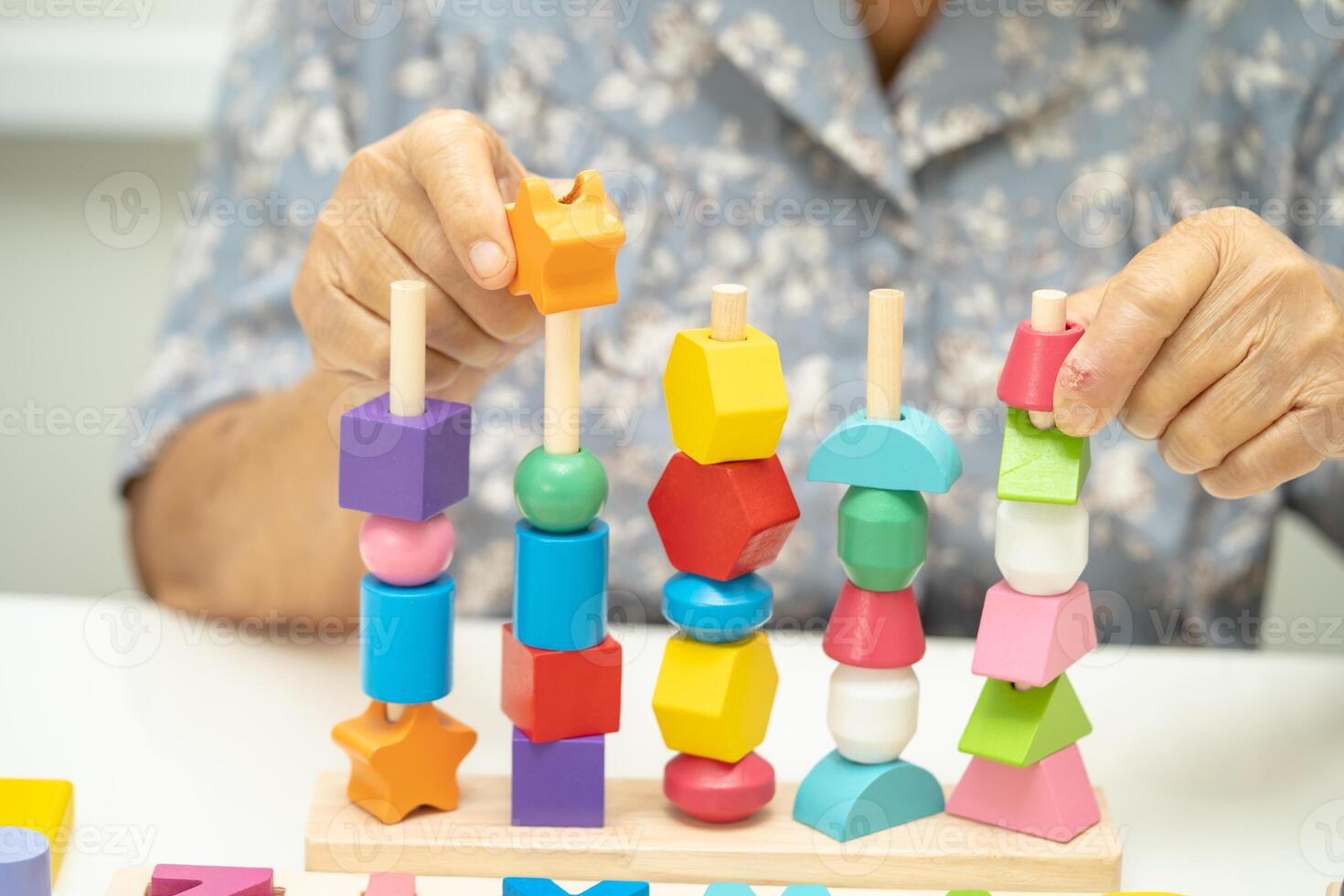 Alzheimer disease AD, Asian elderly woman patient suffering from dementia learn practical motor skills rehabilitation. photo