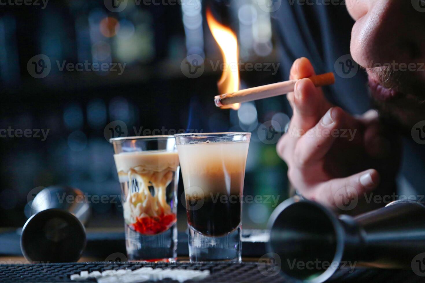 Man Smoking Cigarette Next to Glass of Liquid photo