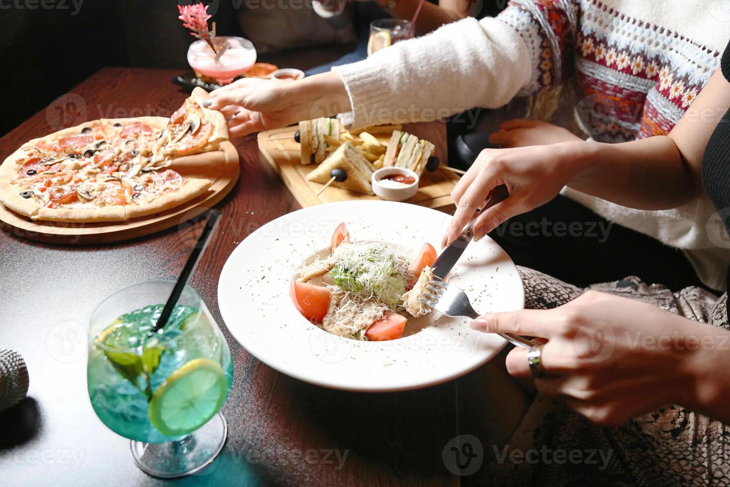 grupo de personas disfrutando un comida juntos a un mesa foto