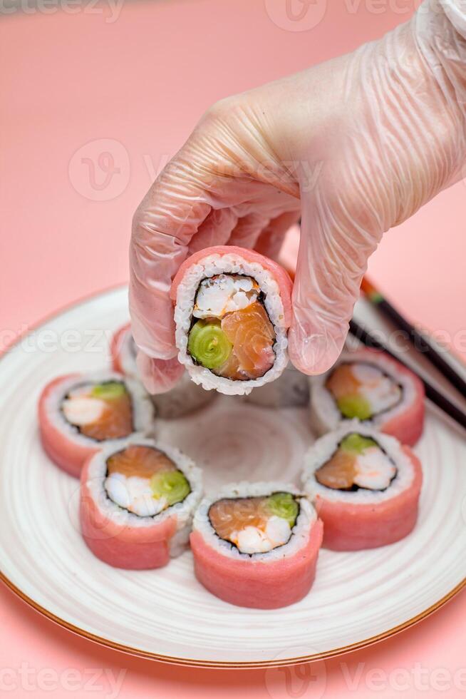 Person Holding Sushi on Plate photo