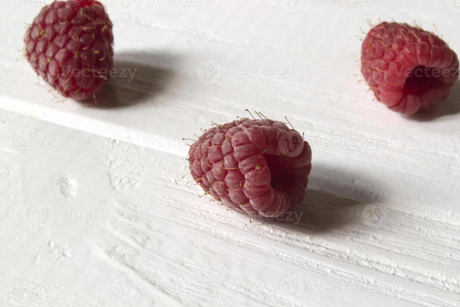 Ripe raspberries on a white wooden background. photo