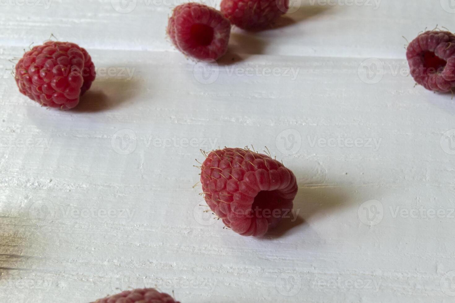Ripe raspberries on a white wooden background. photo
