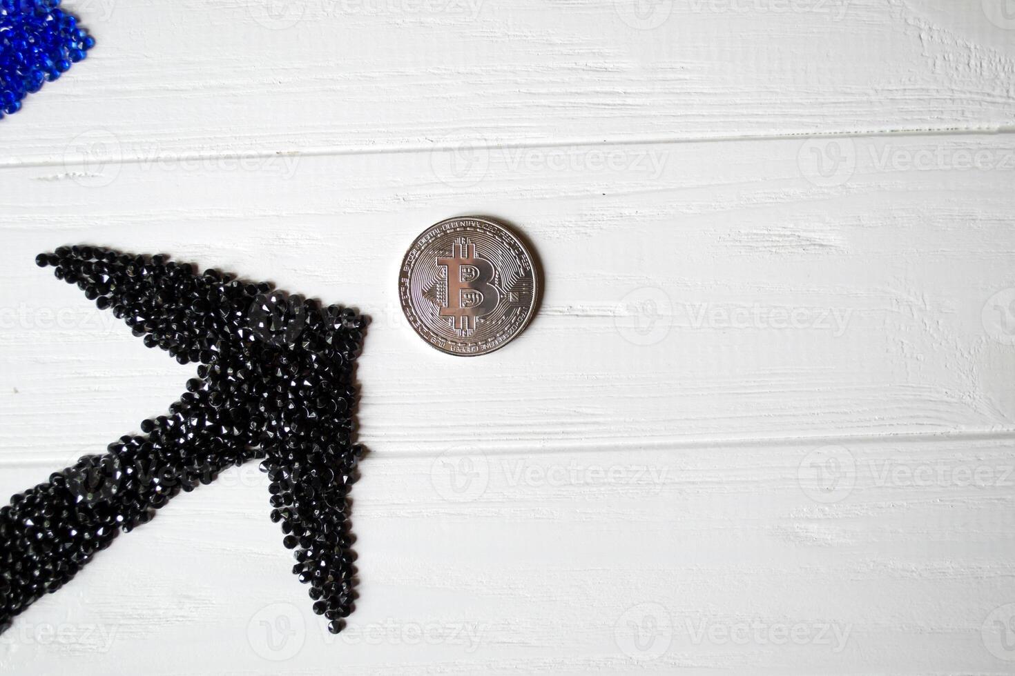 Silver bitcoin with black arrow up on a white wooden background. photo