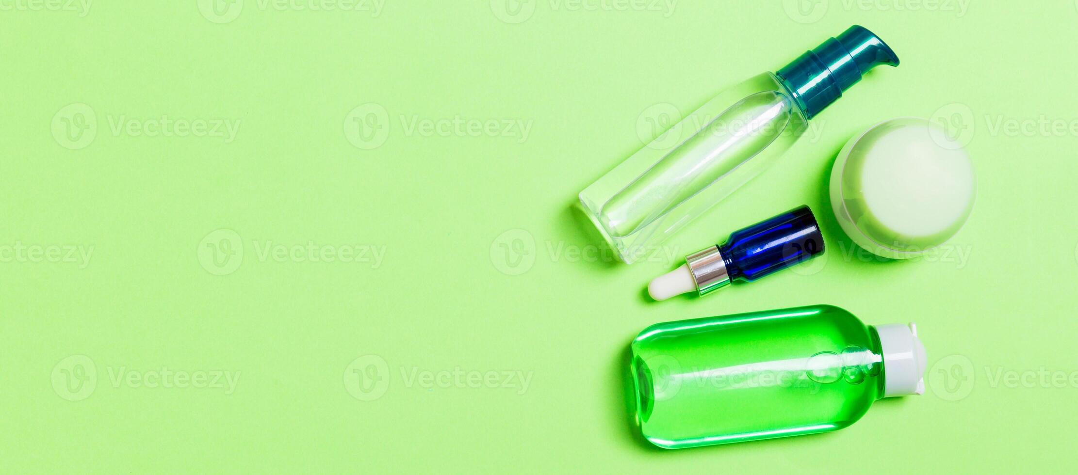Cosmetics SPA branding mock-up, top view with copy space. set of tubes and jars of cream flat lay on gren background photo