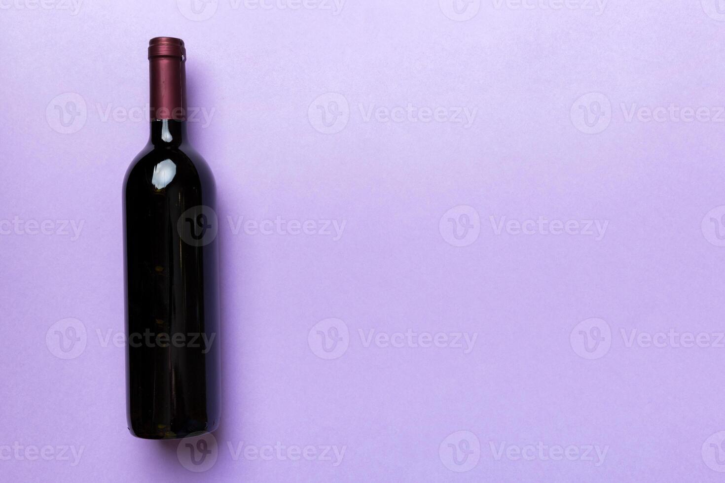 One Bottle of red wine on colored table. Flat lay, top view wth copy space photo