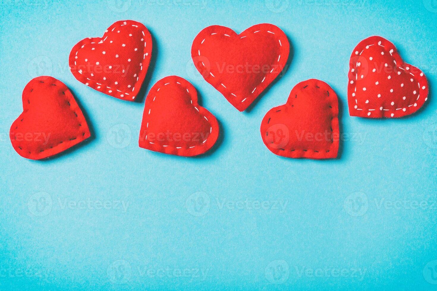 Composition of textile red hearts on colorful background with empty space for your design. Top view of St. Valentine's day concept photo