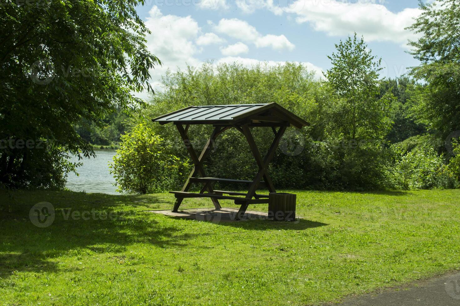 verano cenador en el verde prado cerca lago. foto