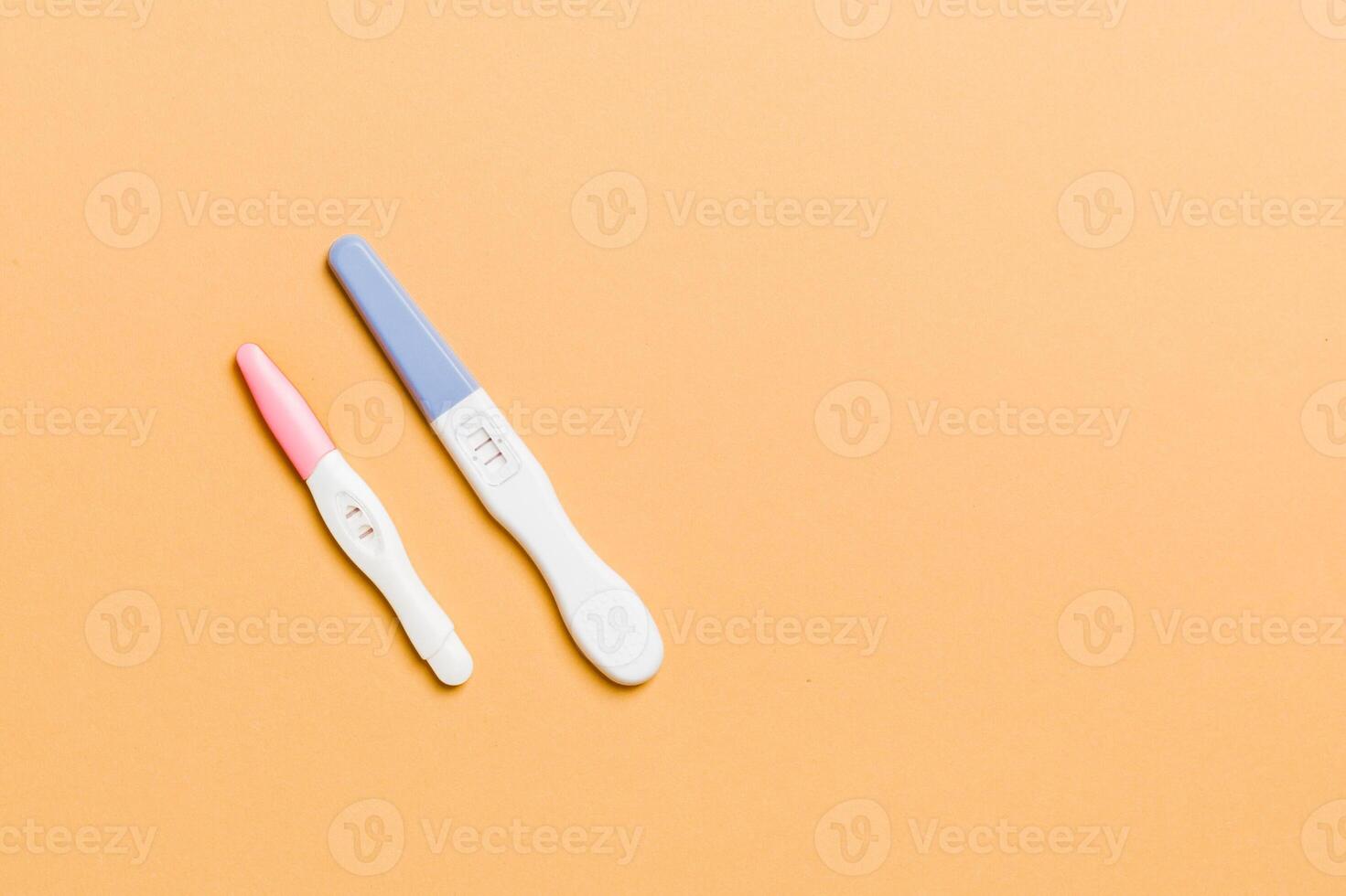 Colored Pregnancy test on colored background, top view with copy space photo