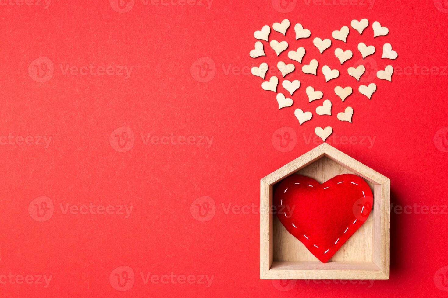 Top view of red textile heart in a wooden house decorated with small hearts on colorful background. Shape of heart. Home sweet home. Valentine's day concept photo