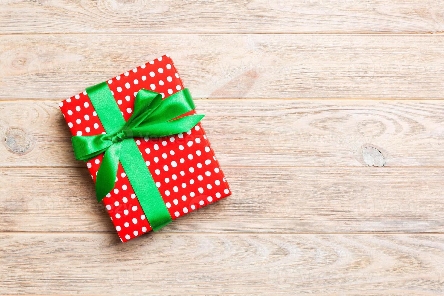 paper gift box with colored ribbon on orange wood background. top view with copy space Christmas holiday concept photo