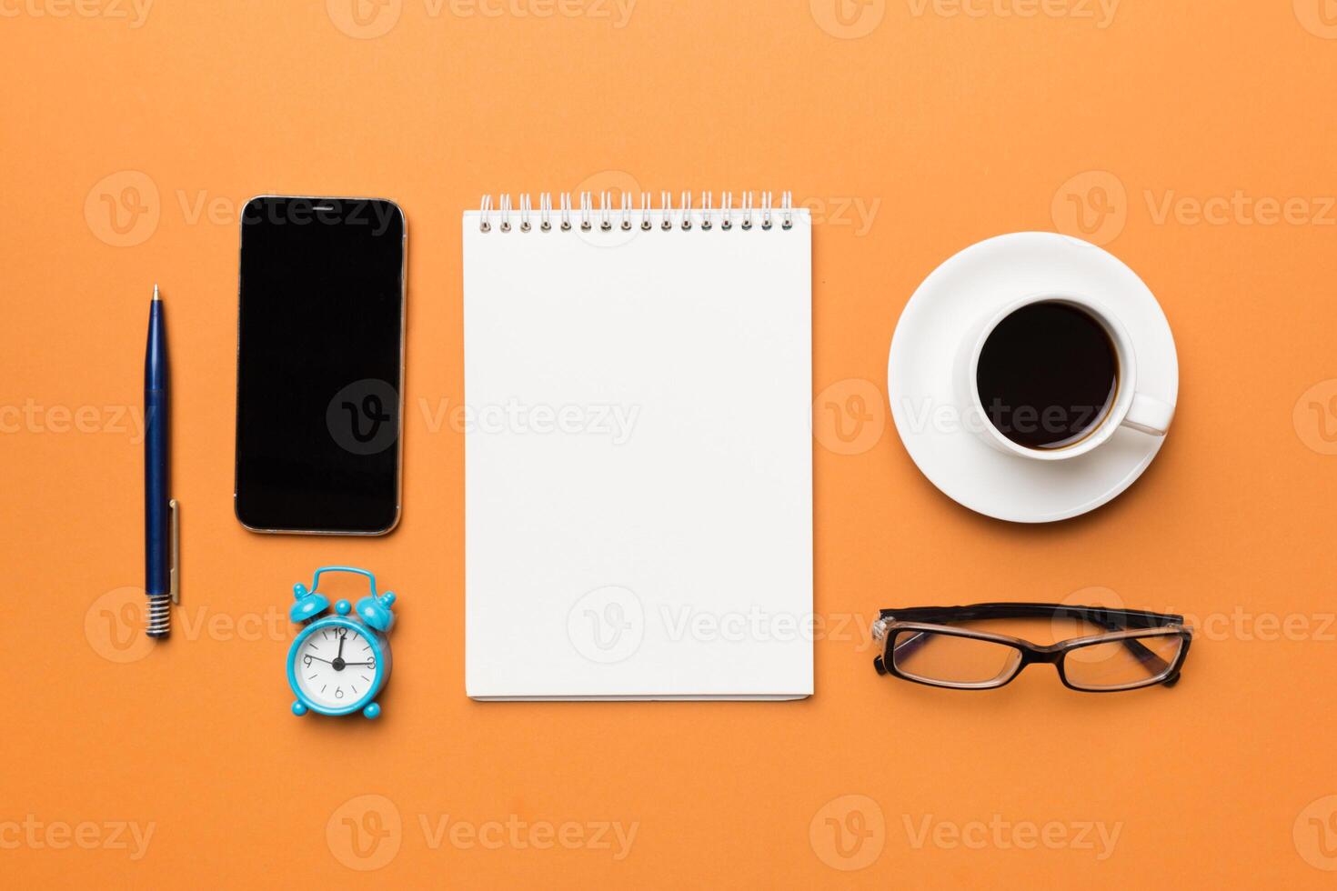 Modern office desk table with notebook, smartphone and other supplies with cup of coffee. Blank notebook page for you design. Top view, flat lay photo