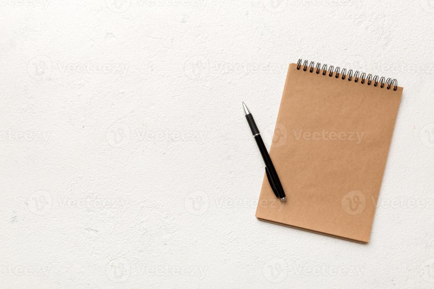 school brown notebook on a colored background, spiral craft notepad on a table Top view photo