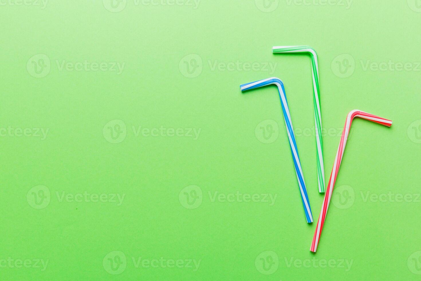 Drinking straws for party on Colored background. Top view of colorful plastic disposable straws for summer cocktails. different straws for juice with copy space photo