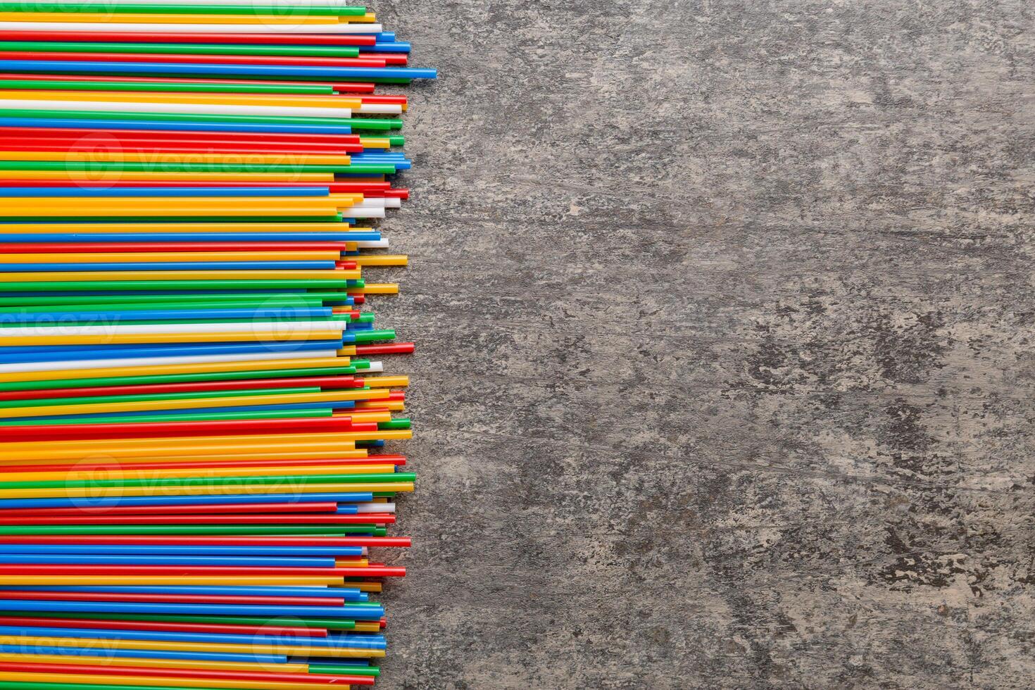 Heap of colorful plastic drinking straws on Colored background, flat lay. Copy Space for text photo