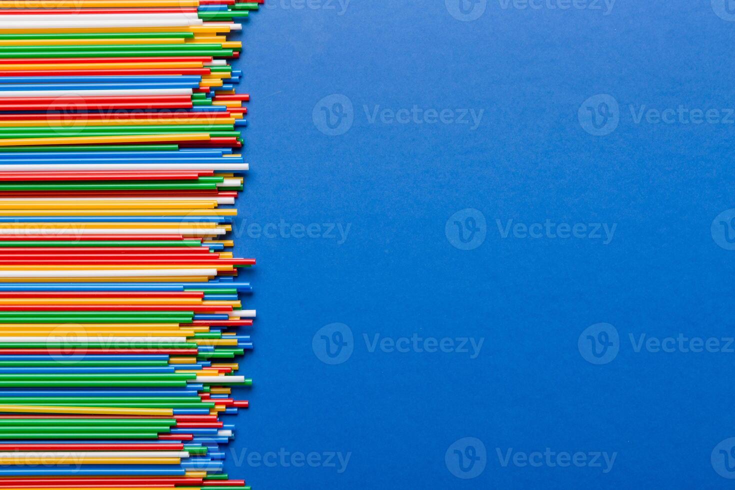 Heap of colorful plastic drinking straws on Colored background, flat lay. Copy Space for text photo