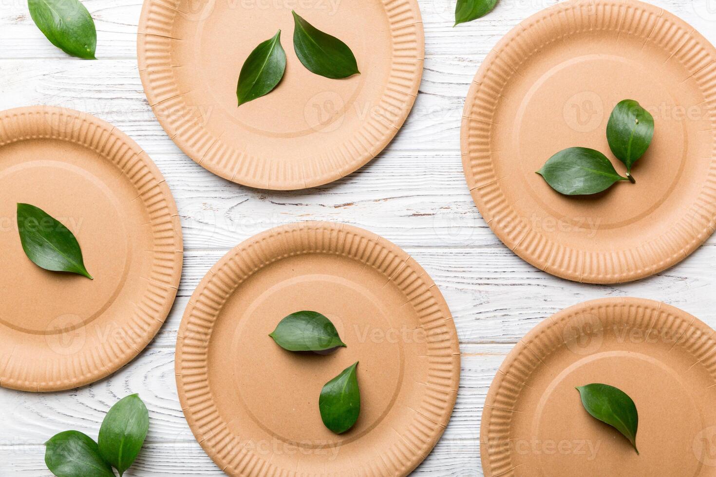 set of empty reusable disposable eco-friendly plates, cups, utensils on light white colored table background. top view. Biodegradable craft dishes. Recycling concept. Close-up photo