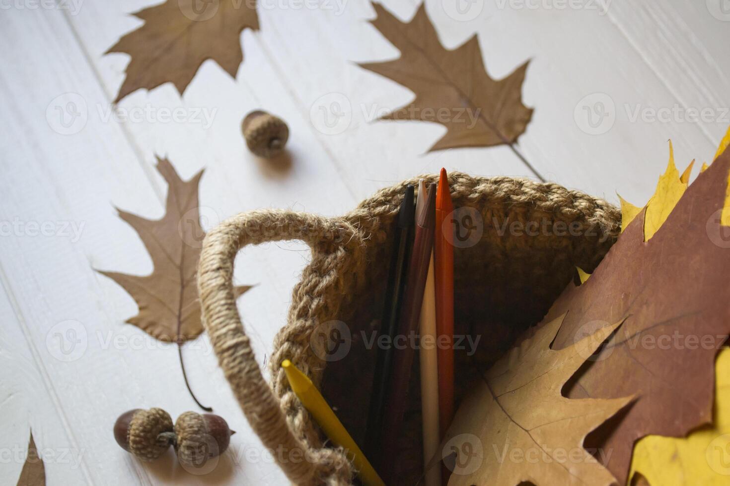 Autumn leaves in a basket on the desk. photo