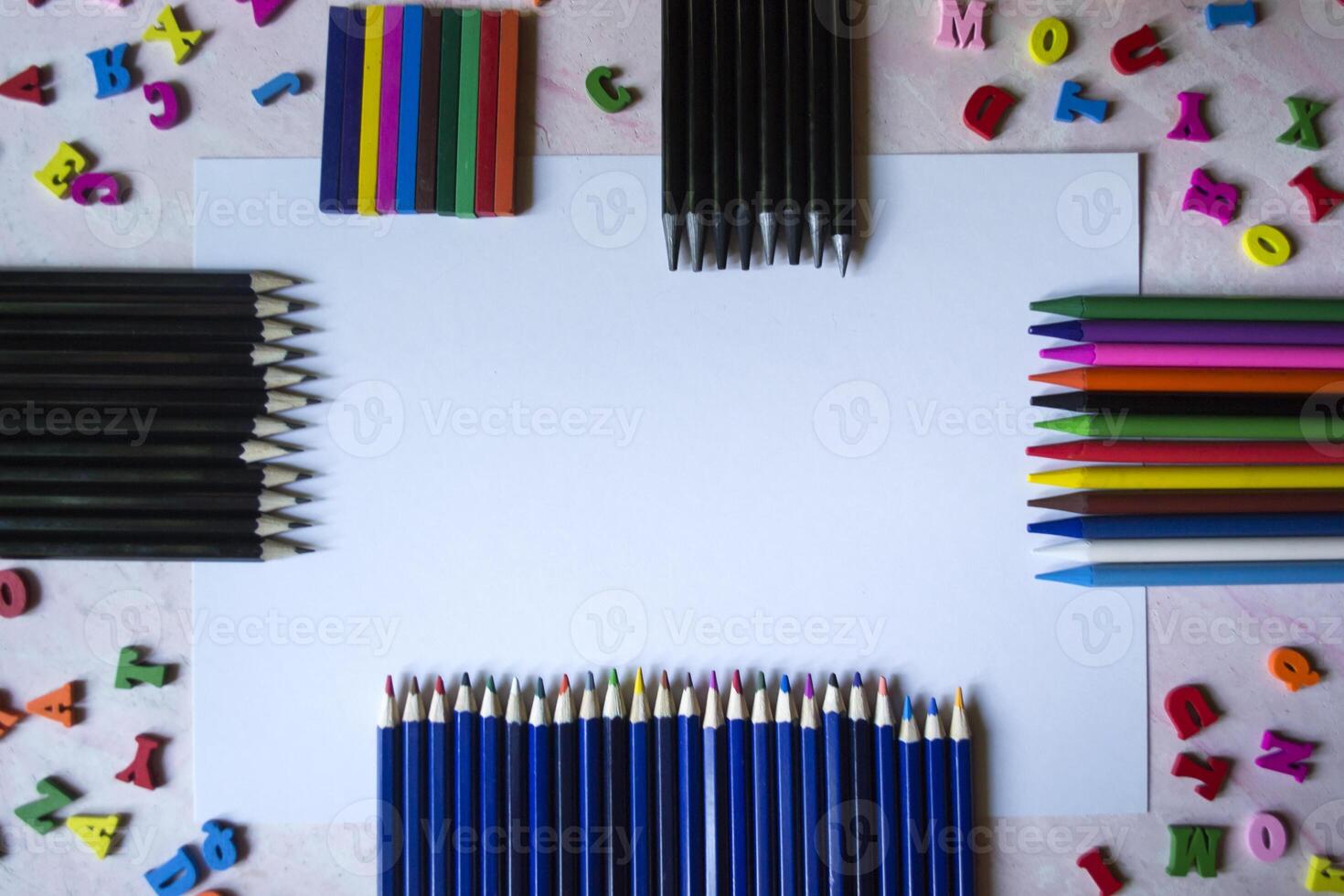 Multicolor letters and set of pencils on the table. Colorful wooden alphabet and pencils on a table. photo