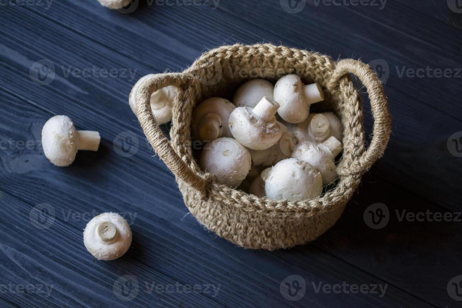 The champignons in a basket on a wooden table. photo