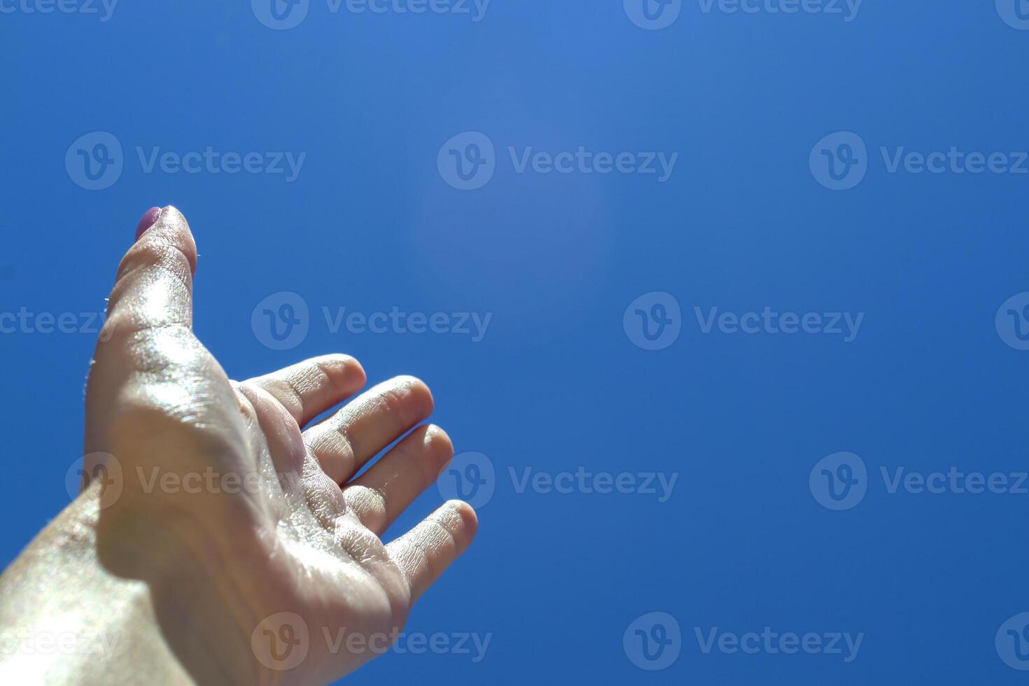 Female arm against a blue sky background. photo