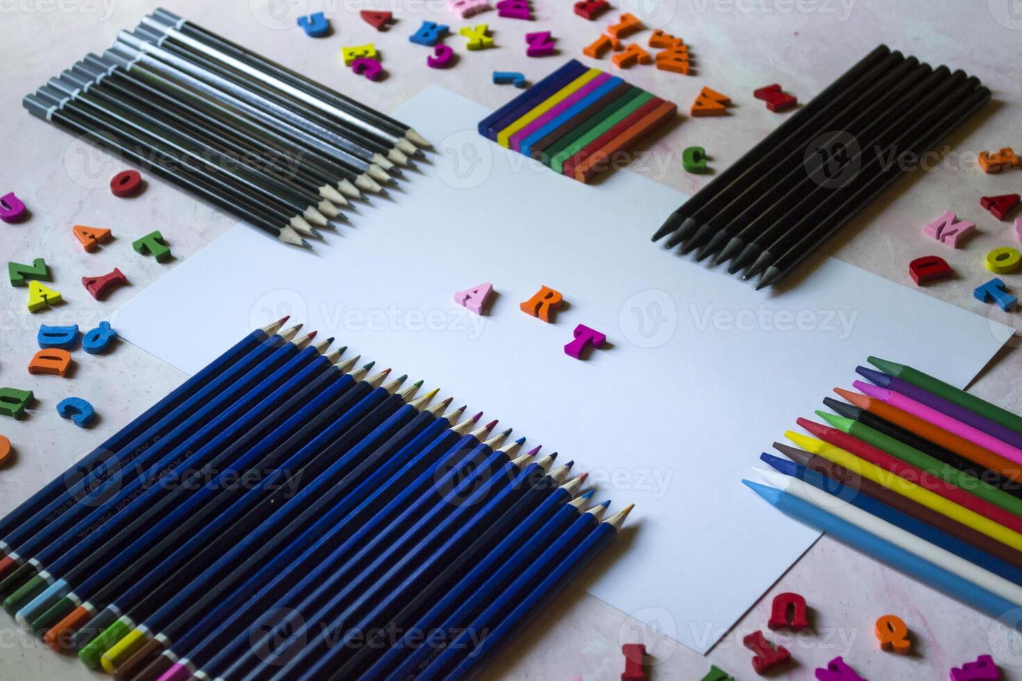 Multicolor letters and set of pencils on the table. Colorful wooden alphabet and pencils on a table. photo