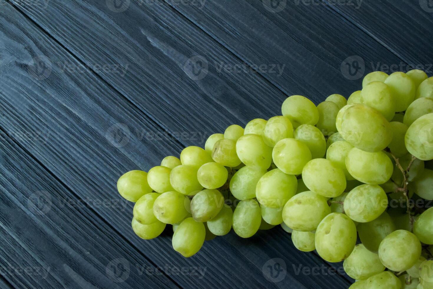 Ripe grapes in a plate on a dark blue wooden table. photo