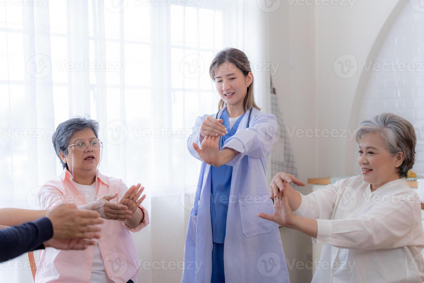 Portrait of elderly smiling Asian woman and people aerobics in nursery house. Seniors are moving their body arms and shoulders for a healthy life. retired people activities group concept. photo