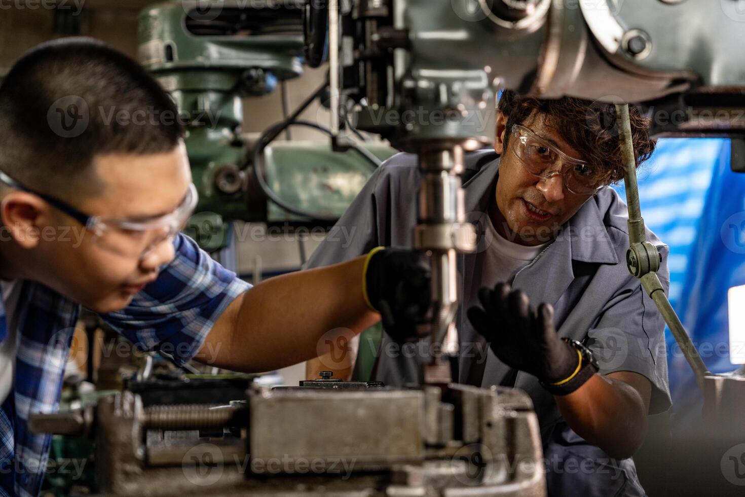 asiático trabajador en producción planta perforación a máquina. profesional trabajador cerca perforación máquina en fábrica. refinamiento metal trabajando interno acero superficie en torno amoladora máquina con volador chispas. foto