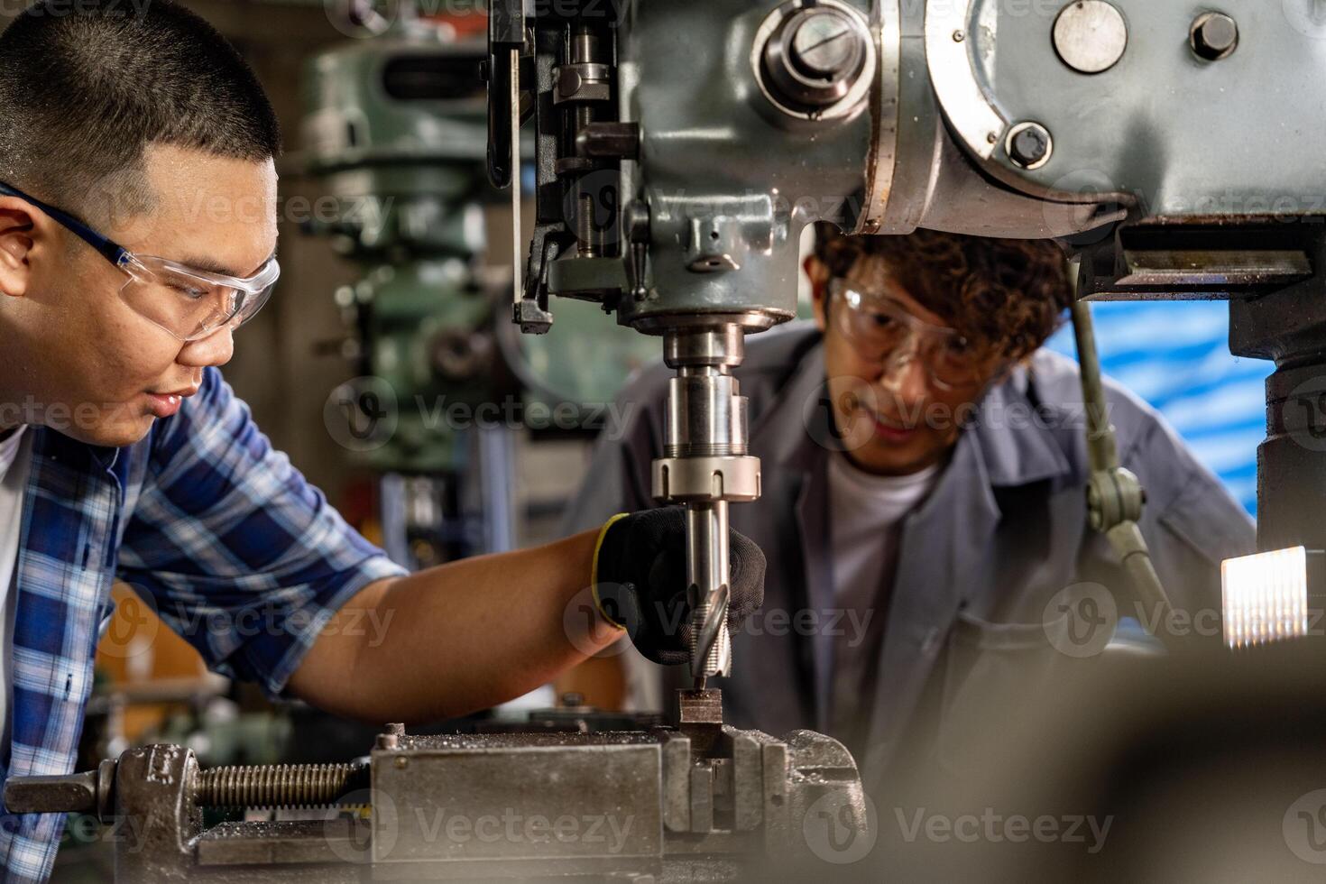 asiático trabajador en producción planta perforación a máquina. profesional trabajador cerca perforación máquina en fábrica. refinamiento metal trabajando interno acero superficie en torno amoladora máquina con volador chispas. foto