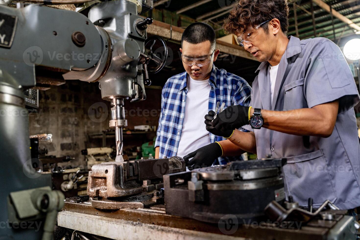 Asian worker in production plant drilling at machine. Professional worker near drilling machine on factory. finishing metal working internal steel surface on lathe grinder machine with flying sparks. photo