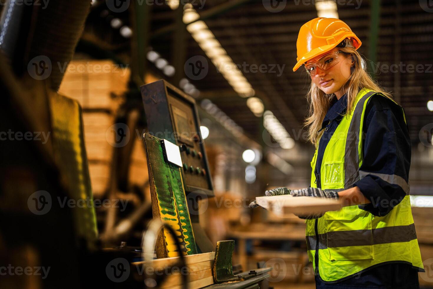 Factory engineer woman standing confident to control panel switch. Worker works at heavy machine at industry factory. worker checking timber of raw wood material. smart industry worker operating. photo