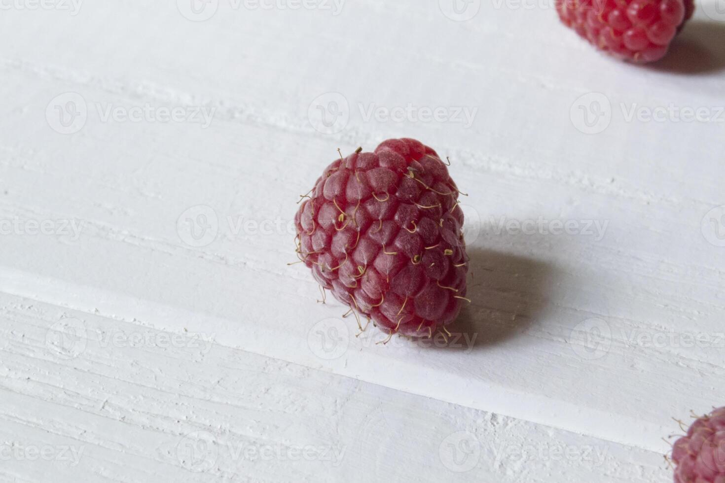 Ripe raspberries on a white wooden background. photo