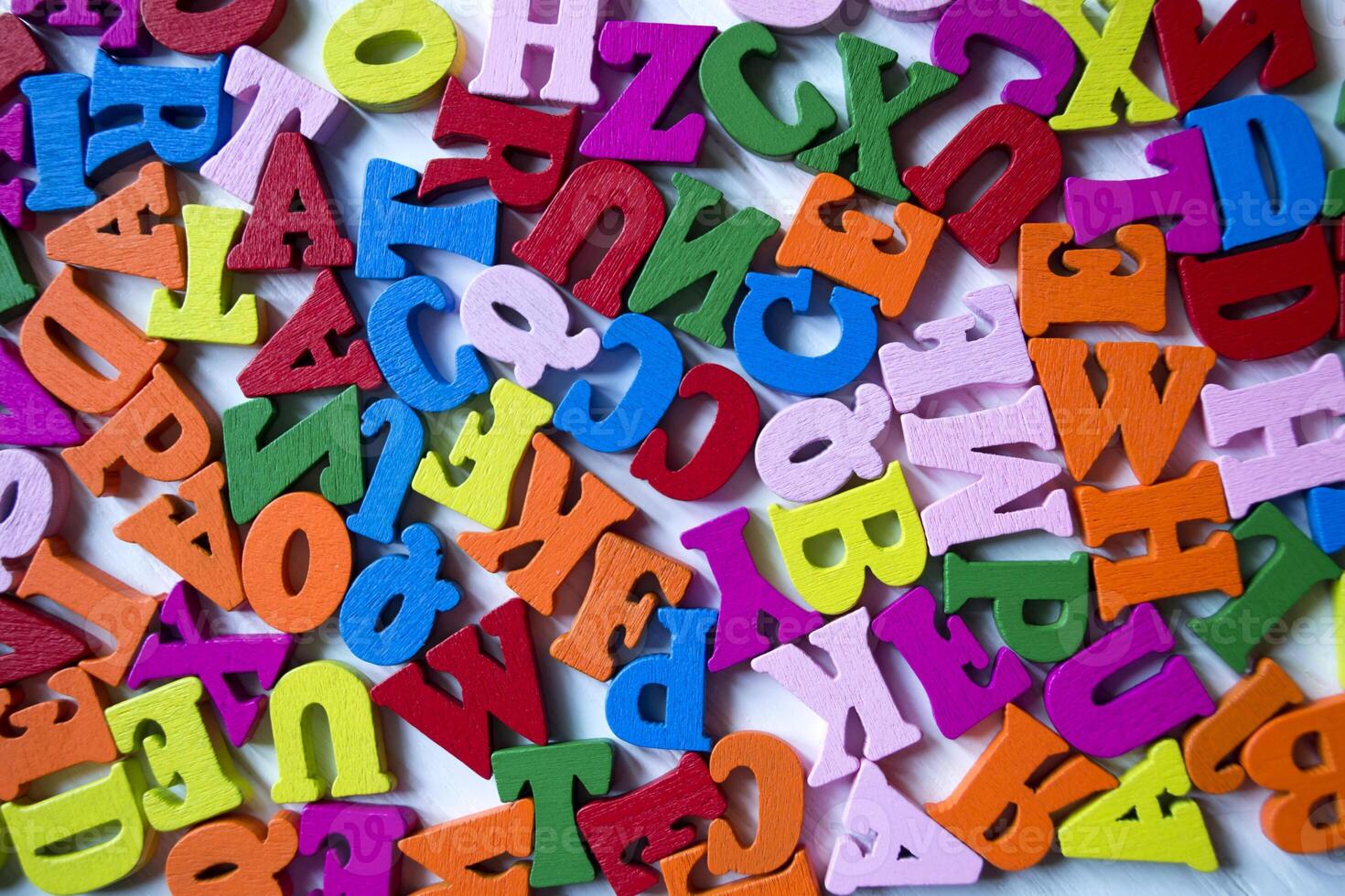 Multicolor letters on a white wooden background. Colorful wooden alphabet on a table. photo