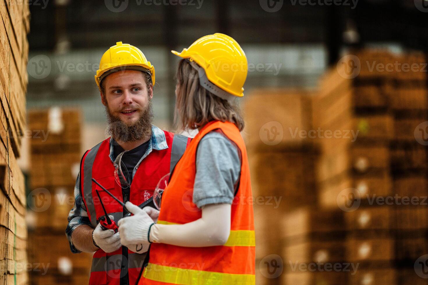 Team workers carpenter wearing safety uniform and hard hat working and checking the quality of wooden products at workshop manufacturing. man and woman workers wood in dark warehouse industry. photo