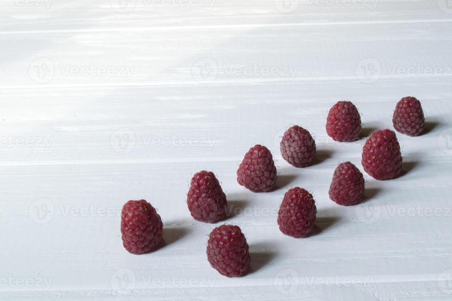 Ripe raspberries on a white wooden background. photo