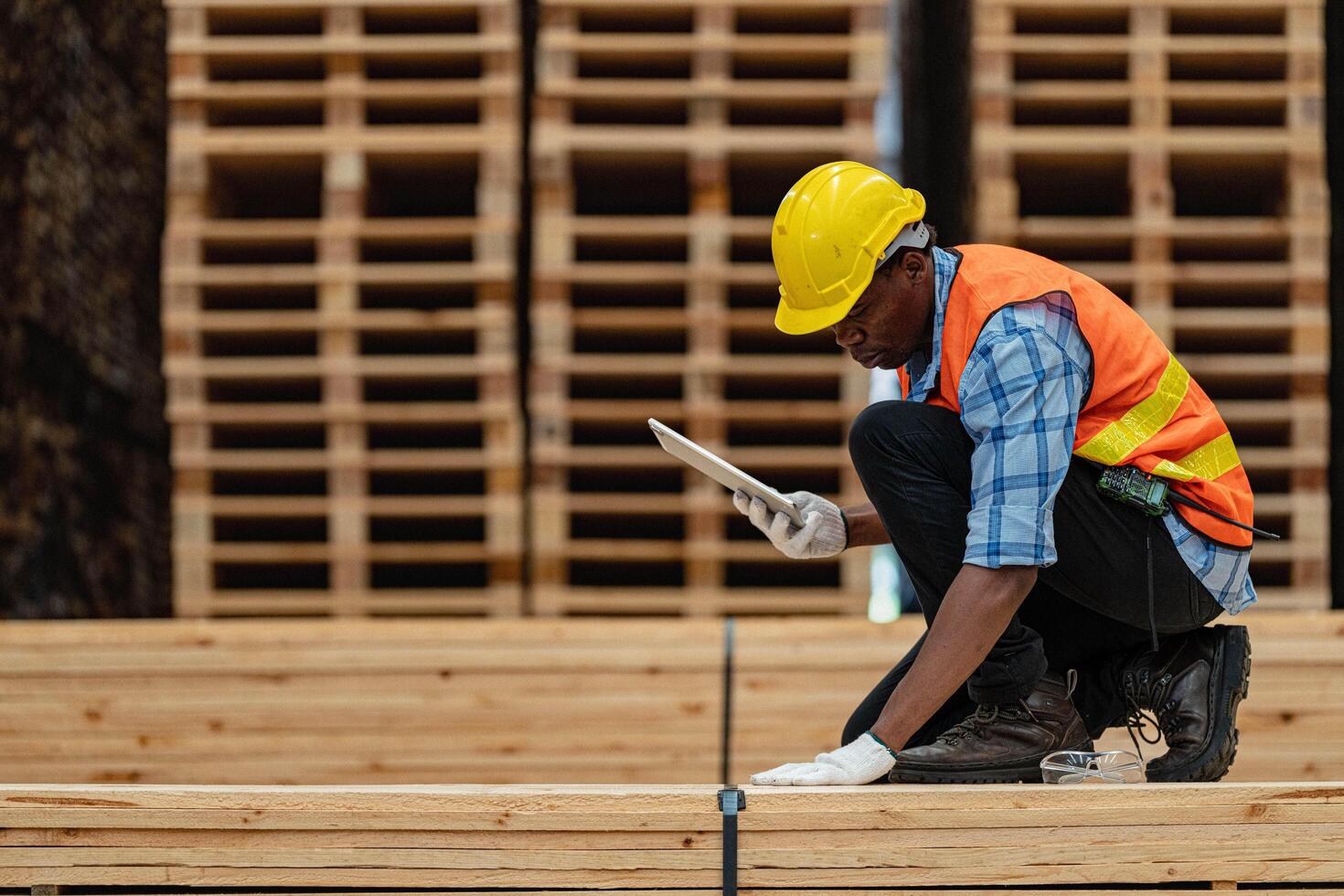 African workers man engineering walking and inspecting with working suite dress and hand glove in timber wood warehouse. Concept of smart industry worker operating. Wood factories produce wood palate. photo