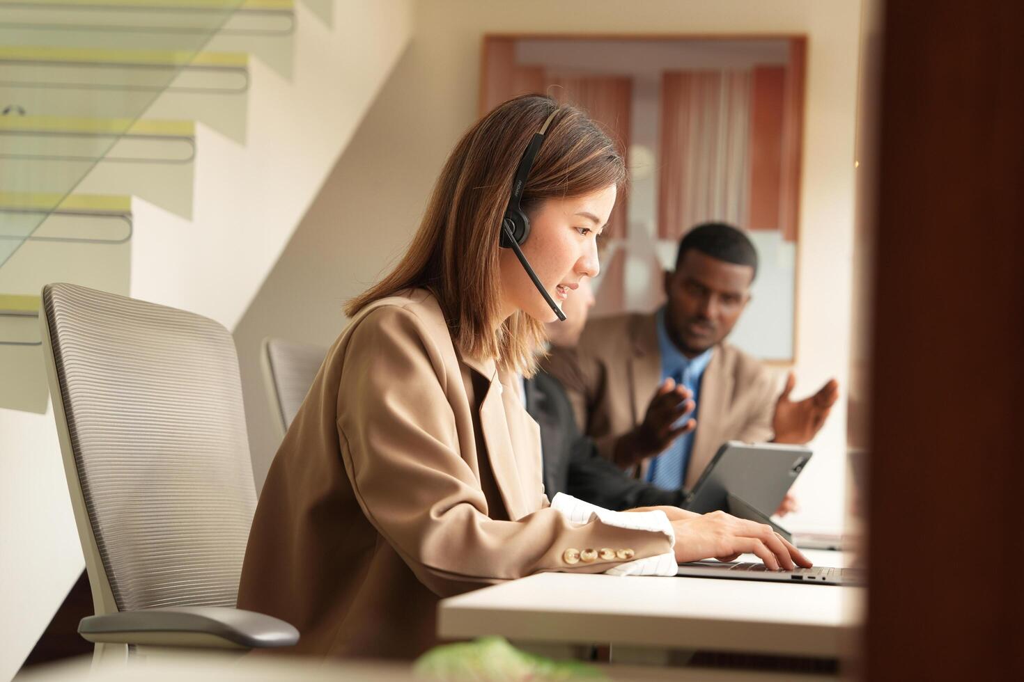Asian operator working in office. Young friendly operator woman agent with headsets working in a call centre. photo