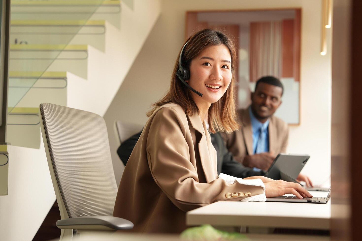 Asian operator working in office. Young friendly operator woman agent with headsets working in a call centre. photo