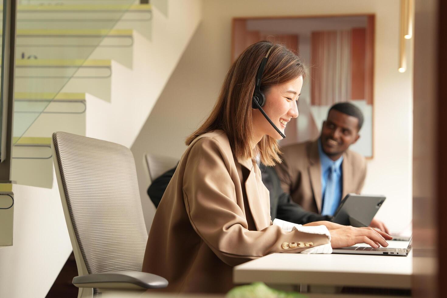 Asian operator working in office. Young friendly operator woman agent with headsets working in a call centre. photo