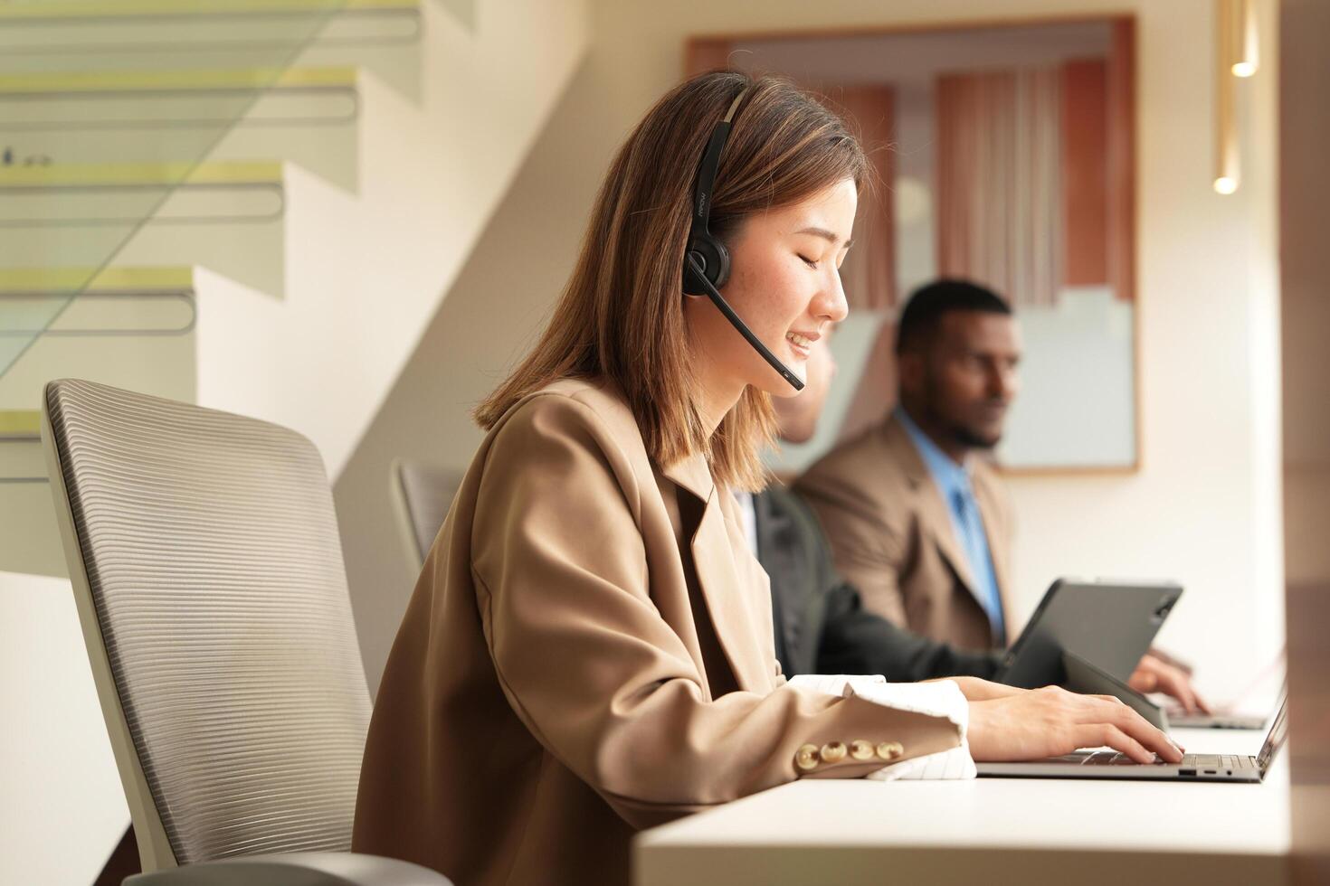Asian operator working in office. Young friendly operator woman agent with headsets working in a call centre. photo