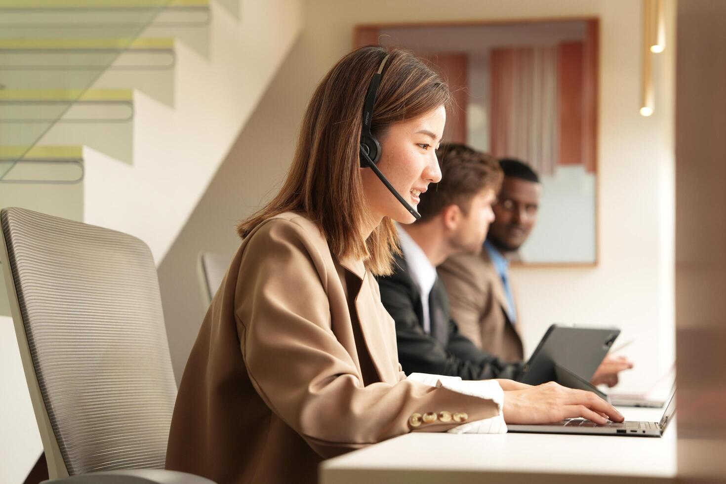 Asian operator working in office. Young friendly operator woman agent with headsets working in a call centre. photo
