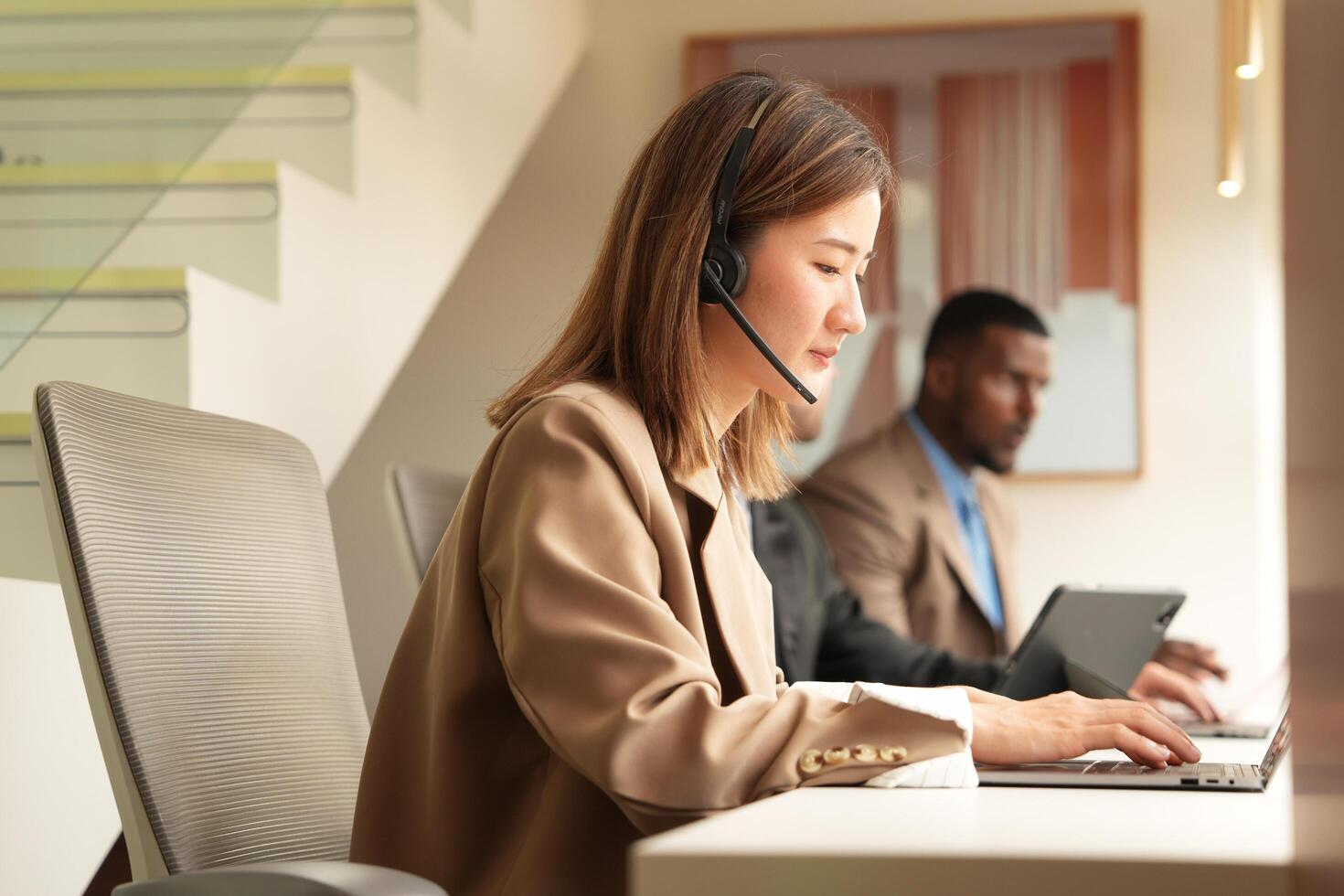 Asian operator working in office. Young friendly operator woman agent with headsets working in a call centre. photo