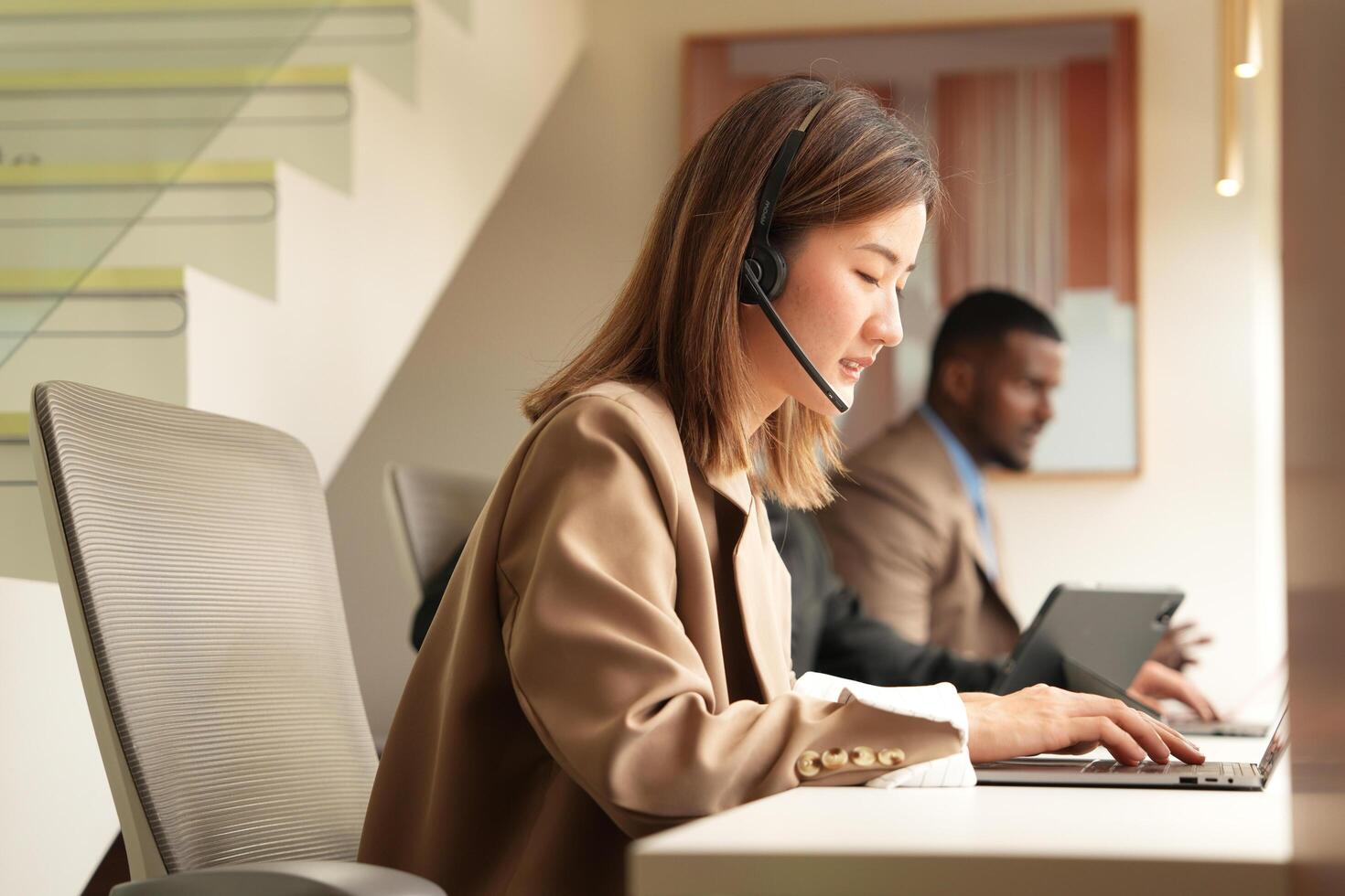 Asian operator working in office. Young friendly operator woman agent with headsets working in a call centre. photo