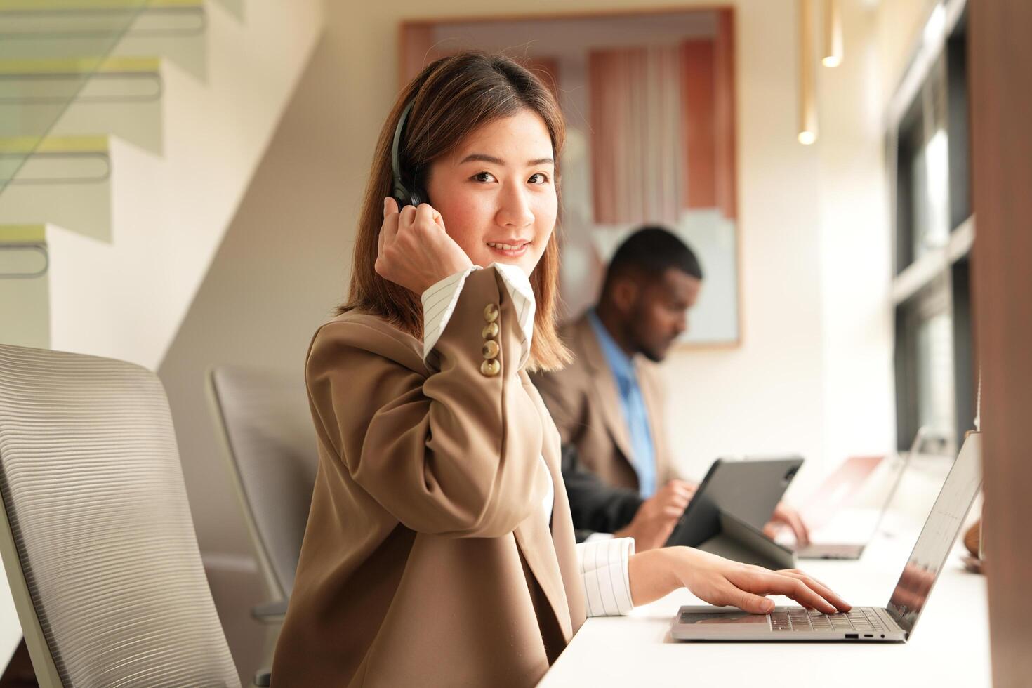 Asian operator working in office. Young friendly operator woman agent with headsets working in a call centre. photo