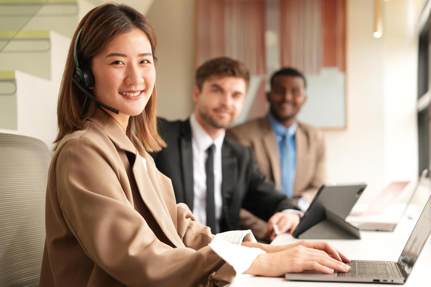 Asian operator working in office. Young friendly operator woman agent with headsets working in a call centre. photo