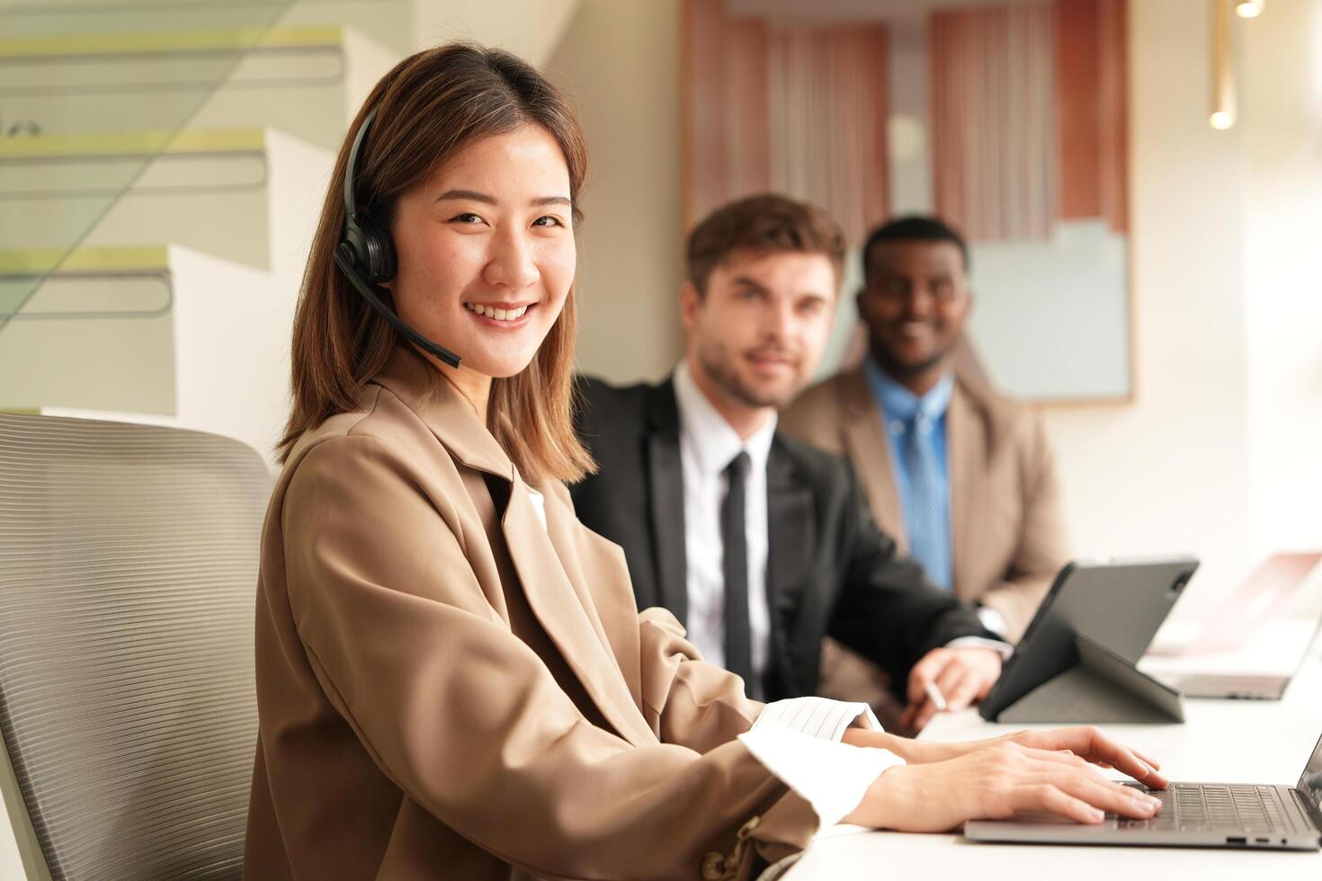 Asian operator working in office. Young friendly operator woman agent with headsets working in a call centre. photo