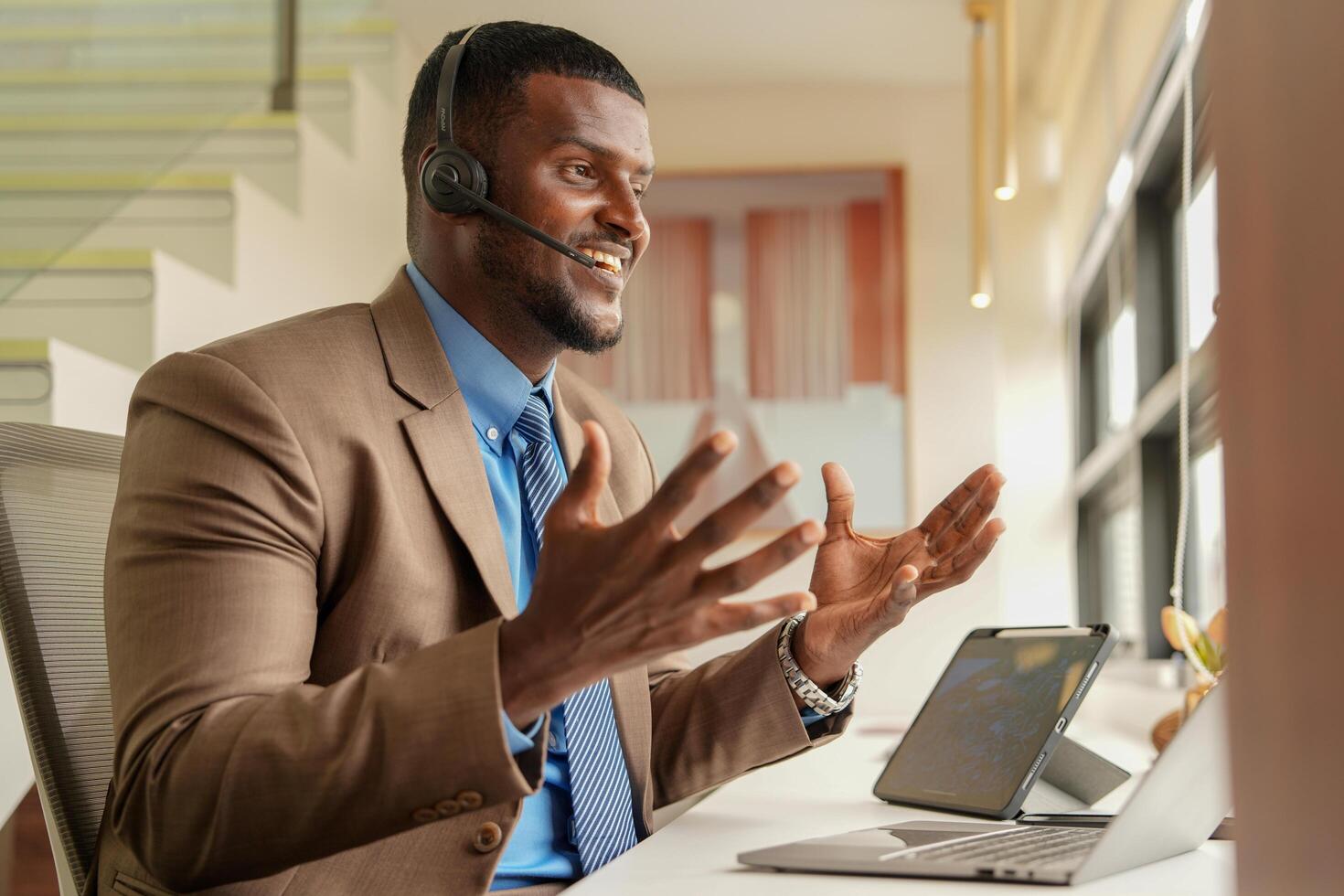 cliente apoyo llamada centrar operador o recepcionista. cliente Servicio y hombre consultor hablando mientras haciendo un consulta en línea. africano operador masculino telemarketing agente en un ordenador portátil en oficina foto