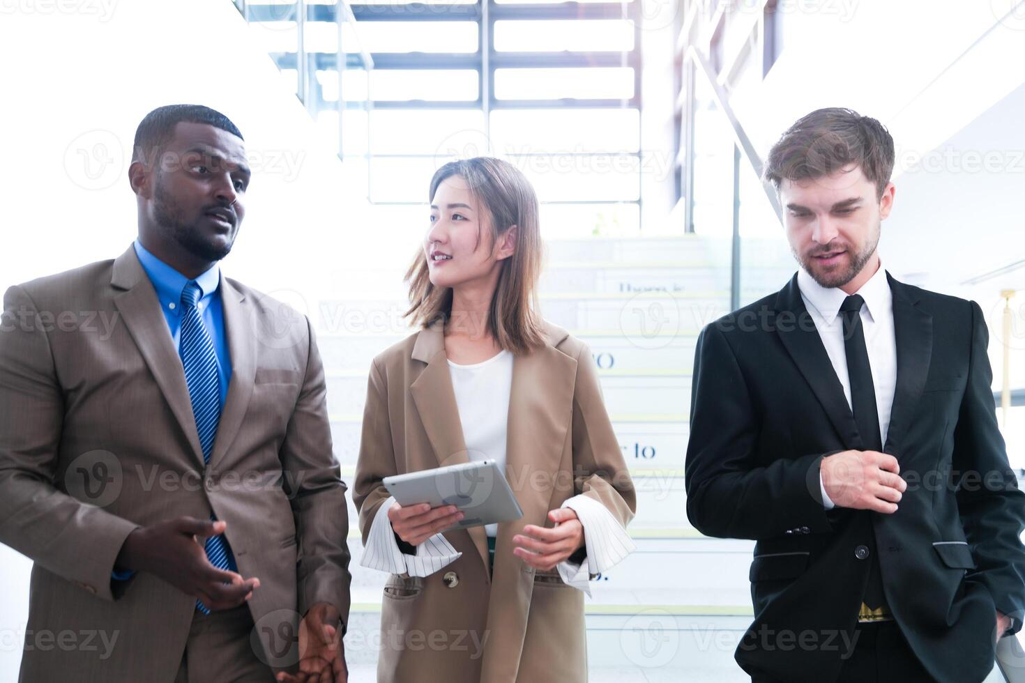 Business people shaking hands. finishing up a meeting. team of business people walk in rush hour at indoor pedestrian stairs and talk together. concept negotiations in feeling successful and happy. photo