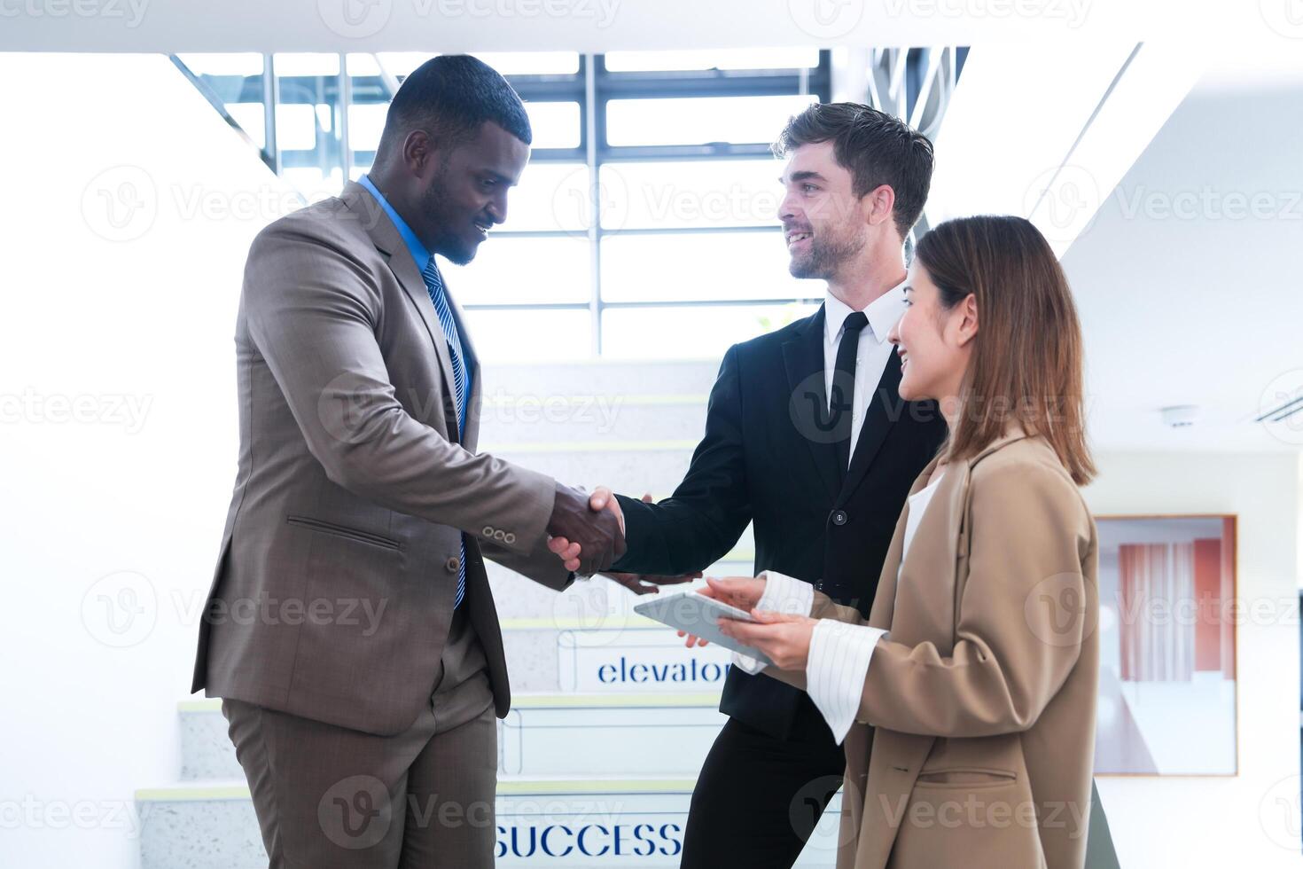 Business people shaking hands. finishing up a meeting. team of business people walk in rush hour at indoor pedestrian stairs and talk together. concept negotiations in feeling successful and happy. photo