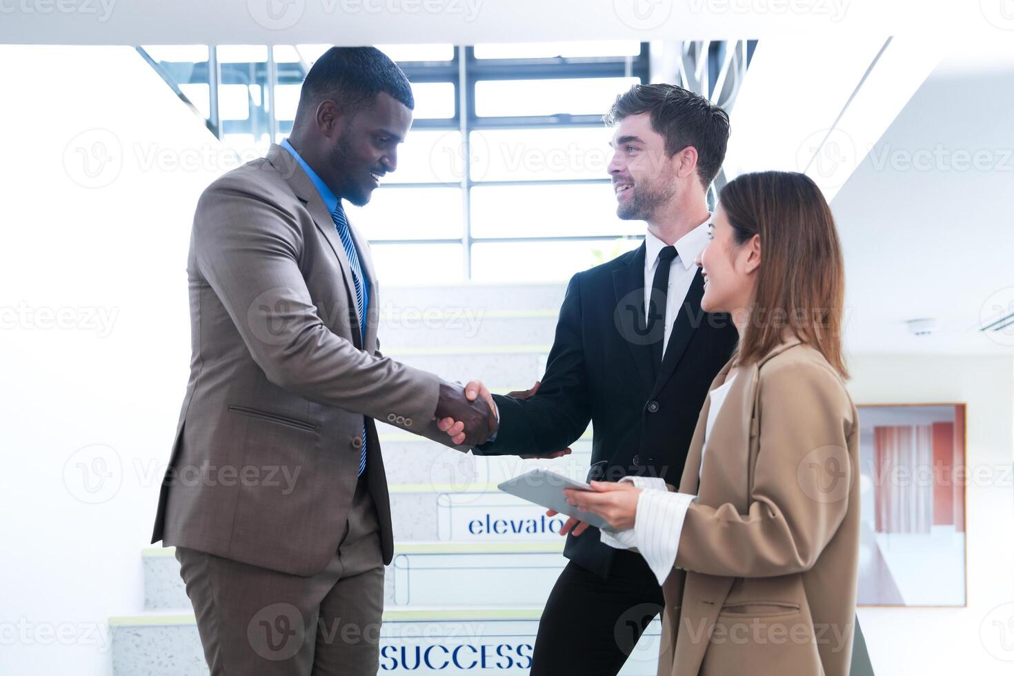 Business people shaking hands. finishing up a meeting. team of business people walk in rush hour at indoor pedestrian stairs and talk together. concept negotiations in feeling successful and happy. photo